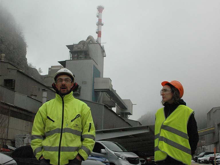 Das Kohlendioxid, das dem Hochkamin entweicht, ist ein entscheidender Treiber für die Kreislaufwirtschaft in der Zementproduktion. Links: Mathieu Antoni, Umweltverantwortlicher der Vigier AG; rechts: Mirjam Wolffers von der Universität Bern.