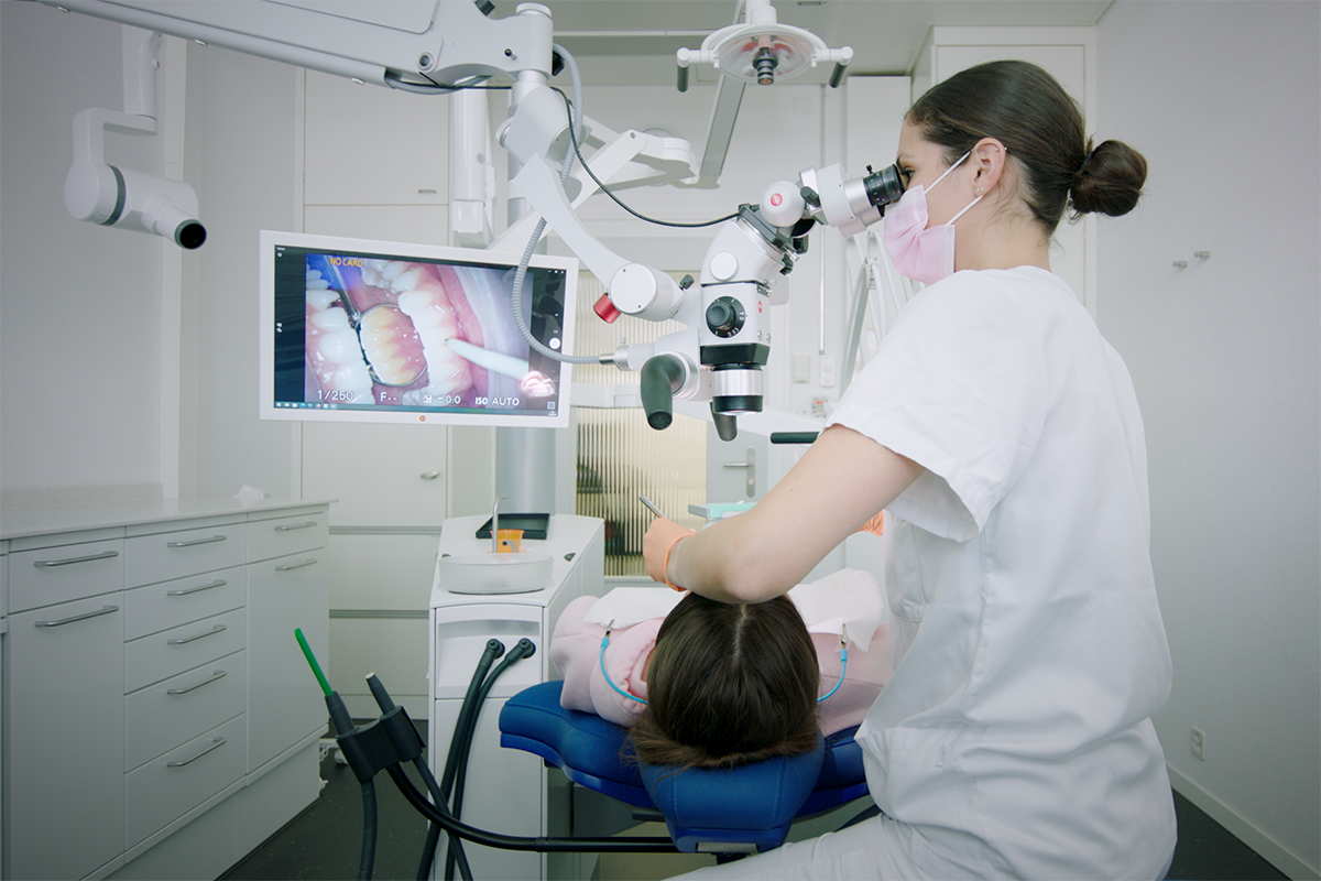 Aktuelles Behandlungszimmer der zmk Bern mit Mikroskop und Röntgen an der Dentaleinheit. © zmk