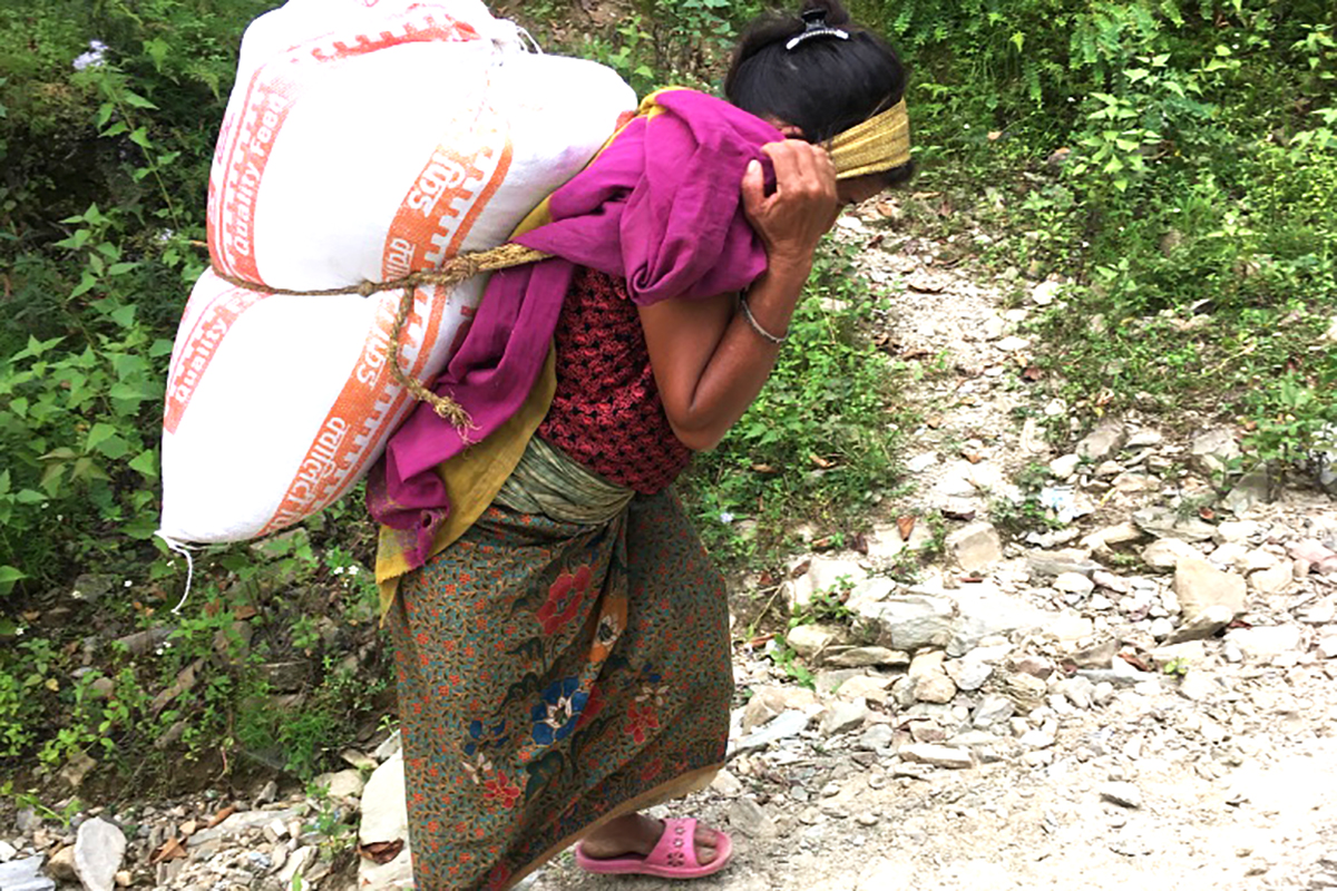 Eine Frau in Nepal trägt Tierfutter: das Heben und Tragen schwerer Lasten stellt ein gesundheitliches Risiko dar. © zvg