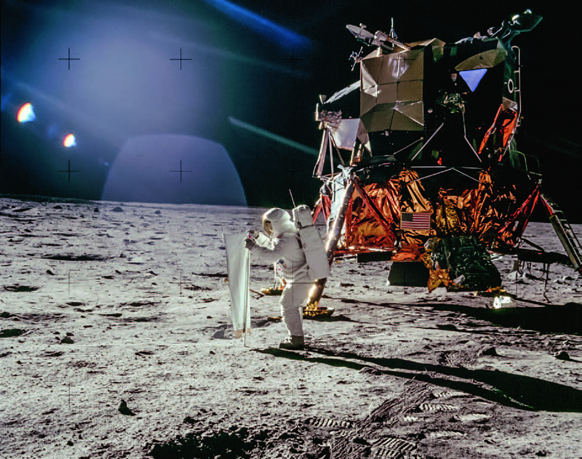 Buzz Aldrin entrollt anlässlich der ersten Landung auf dem Mond am 21. Juli 1969 das Sonnenwindsegel der Universität Bern. © NASA, Apollo Image Archive