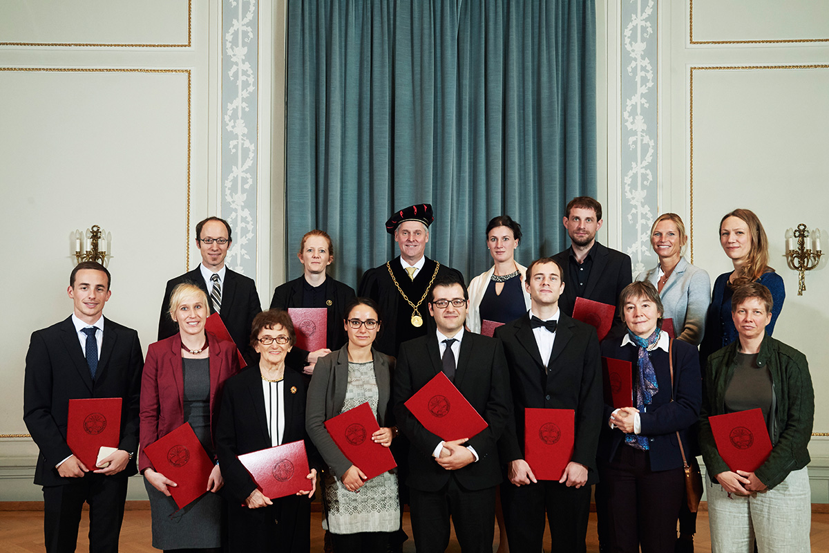 14 Forschende wurden am diesjährigen Dies academicus mit akademischen Preisen geehrt. Obere Reihe von links nach rechts: Dr. theol. Simon Hofstetter, Dr. des. Fabienne Amlinger, Rektor Prof. Dr. Christian Leumann, Dr. Nadine Ebert, Dr. Simon Imhof, Dr. Sonja Kleinlogel, PD Dr. Eva Knop. Untere Reihe von links nach rechts: Dr. Kaspar Wüthrich, Dr. des. Nadine Chariatte, Ehrensenatorin Dr. Celia Zwillenberg, Maria Mittner-Zindel, Dr. Ali Hashemi Gheinani, Dr. Lukas Mager, Prof. Dr. Gabriele C. Hegerl, Dr. Tina Büchler. Auf dem Bild fehlt Dr. des. Nadine Amsler.