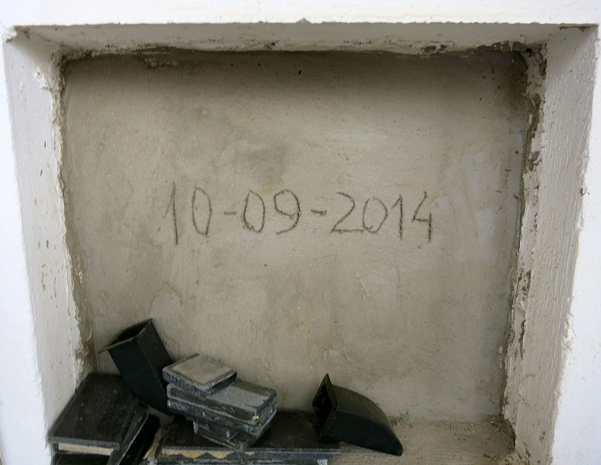 Das Grab eines unbekannten Flüchtlings: Eine Nische, in die CD-Hüllen und Bücher gestapelt wurden. In den Beton der Wand ist das Todesdatum eingeritzt: 10-09-2014.