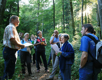 Jürg Schneider redet im Wald vor der versammelten Gruppe